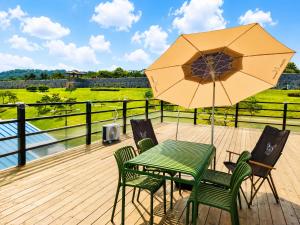 a table and chairs with an umbrella on a deck at Woori Stay in Suwon