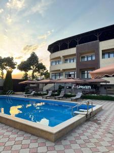a swimming pool in front of a hotel at Asman Hotel in Bosteri