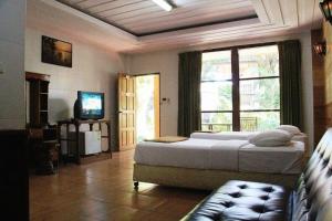 a bedroom with a large bed and a window at Saikaew Villa in Ko Samed