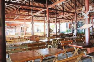 an empty restaurant with wooden tables and benches at Saikaew Villa in Ko Samed