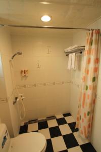 bagno con servizi igienici e pavimento a scacchi di G Home Sir B&B a Magong