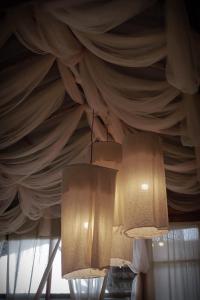 three lights hanging from a ceiling with curtains at Chi Bo ดอยช้าง in Ban Huai Khai