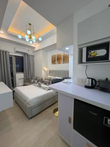 a kitchen and living room with a bed in a room at Azzure North Pampanga Cloudline Suite 418 Barbados in San Fernando