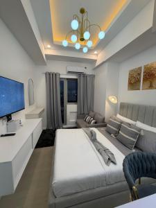 a bedroom with a large bed and a couch at Azzure North Pampanga Cloudline Suite 418 Barbados in San Fernando