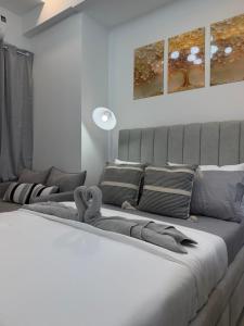 a bedroom with a large white bed with pillows at Azzure North Pampanga Cloudline Suite 418 Barbados in San Fernando