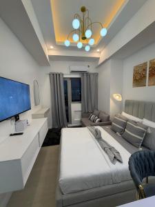 a living room with a large bed and a couch at Azzure North Pampanga Cloudline Suite 418 Barbados in San Fernando +3 photos