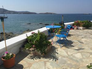 a patio with a table and chairs next to the water at Captain Bay's Unique Heritage Home in Finikas