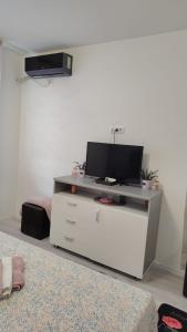 a white entertainment center with a tv on top of it at Garsoniera Monique Luxury in Chiajna