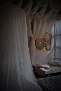 a bedroom with a bed with a white canopy at Chi Bo ดอยช้าง in Ban Huai Khai