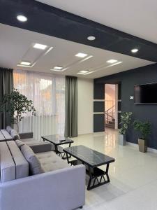 a living room with a couch and tables at Asman Hotel in Bosteri