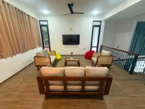 ein Wohnzimmer mit Sofa, Sesseln und Fernseher in der Unterkunft 32AW hotel in Matale