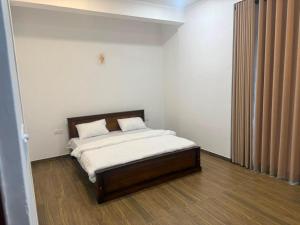 ein Schlafzimmer mit einem Bett mit weißen Laken und Kissen in der Unterkunft 32AW hotel in Matale