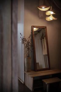 a mirror and a vase on a counter in a room at Chi Bo ดอยช้าง in Ban Huai Khai +6 photos