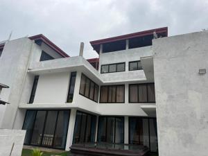 ein großes weißes Gebäude mit großen Fenstern in der Unterkunft 32AW hotel in Matale