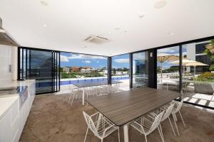 a kitchen and dining room with a table and chairs at Bright CBD 2 bedroom resort-style escape in Brisbane