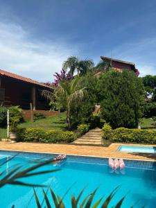 a swimming pool with flip flops in front of a house at Casa com piscina - itupeva in Itupeva