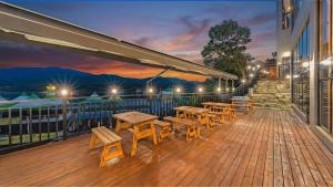 a deck with tables and benches on a building at Gapyeong Sungshine Pension in Gapyeong