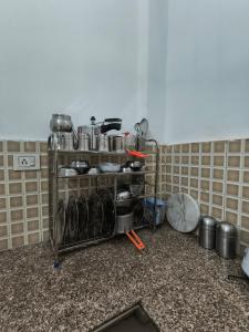 a kitchen with a shelf filled with pots and pans at The Global Nest Homestay 