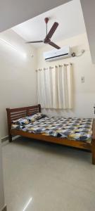 a bed in a room with a ceiling fan at Eden Cozy Villa in Virāmpattinam +9 photos