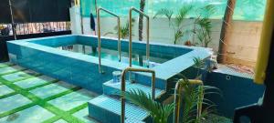 a swimming pool with stairs in the middle at Eden Cozy Villa in Virāmpattinam