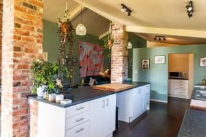 a kitchen with white cabinets and a brick wall at Waimanu Guest House in Franz Josef +36 photos