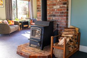 a fireplace in a living room with a brick wall at Waimanu Guest House in Franz Josef
