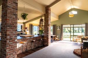 an open kitchen and living room with a brick wall at Waimanu Guest House in Franz Josef
