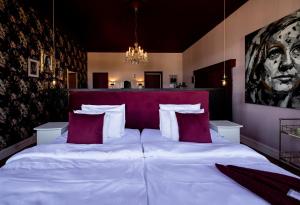 a bedroom with a large white bed with red pillows at Hotell Onyxen, boutique- & lifestyle, Adults Only in Gothenburg