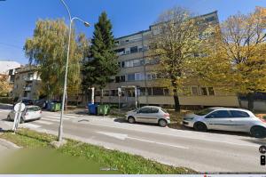 two cars parked on a street in front of a building at Luna apartman in Čačak