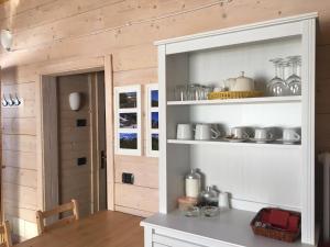 a kitchen with a shelf with dishes on it at Chalet D'Antan in Pila +36 photos