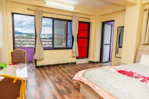a bedroom with a bed and large windows at View point Restaurant and homestay in Kathmandu