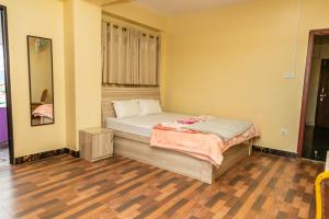 a small bedroom with a bed and a wooden floor at View point Restaurant and homestay in Kathmandu
