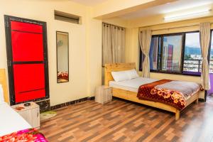 a bedroom with a bed and a large window at View point Restaurant and homestay in Kathmandu