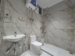 a bathroom with a toilet and a sink at Hotel Satyaki Orchid in Katra +21 photos