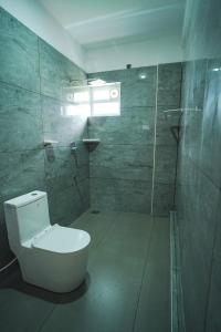 a bathroom with a white toilet and a shower at Grace Residency in Sultan Bathery