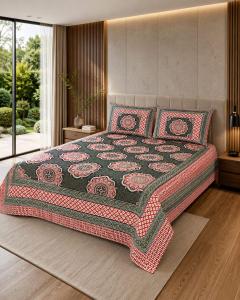 a bedroom with a bed with a quilt on it at Hotel teara in Gwalior
