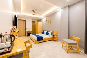 a hotel room with a bed and a desk at Hotel teara in Gwalior