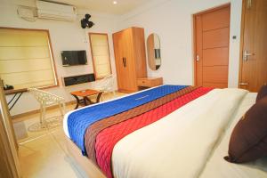 a bedroom with a large bed with a colorful blanket at Grace Residency in Sultan Bathery +15 photos