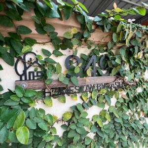 a sign on the side of a building with plants at Homestay by Tas in Kulai