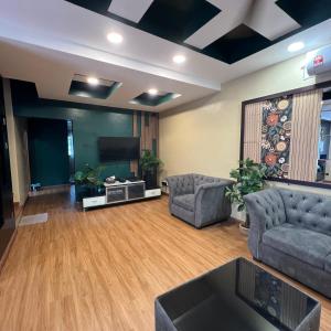 a living room with two couches and a flat screen tv at Homestay by Tas in Kulai
