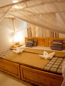 a bedroom with two beds with a canopy at Nam's Homestay in Arusha