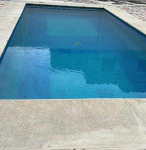 a blue swimming pool next to a sidewalk at Casa Victoria in Colima