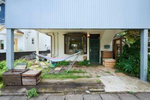 a porch with a hammock in front of a house at Miura Base in Miura
