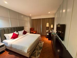 a bedroom with a large bed with red pillows at Besstin Hotel in Hisār