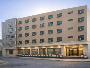 a large building with flowers in front of it at Hotel Apple Park - Near Delhi Airport, Free Airport Trasnfer in New Delhi