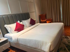 a bedroom with a large white bed with red pillows at Besstin Hotel in Hisār +20 photos