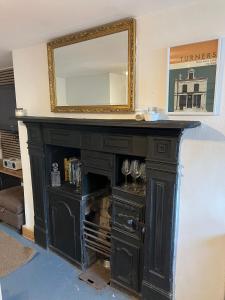 a black fireplace with a mirror on top of it at Albert Road Flat 4 in Colne