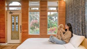 a woman sitting on a bed holding a teddy bear at Seogwipo Neulbada Pet Pension in Seogwipo +12 photos