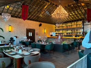 a restaurant with tables and chairs and a bar at Besstin Hotel in Hisār