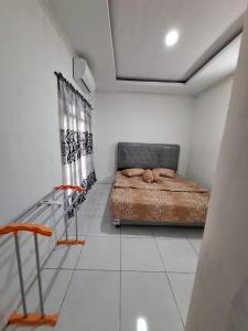 a bedroom with a bed in a white room at YouYouKe Pavillon Karangpapak in Cilauteureun +11 photos